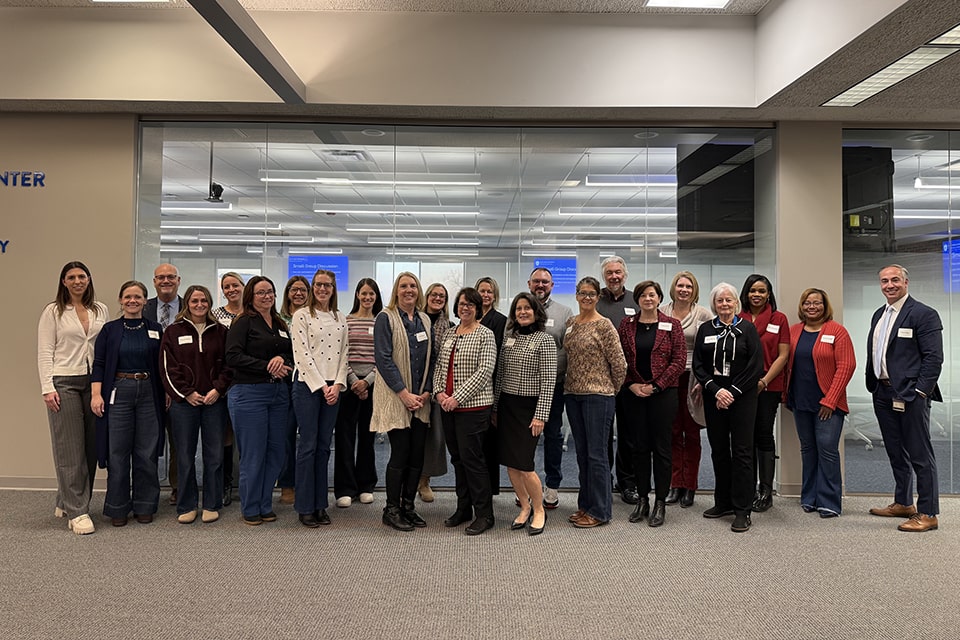 Group members pose for a photo in a meeting room.
