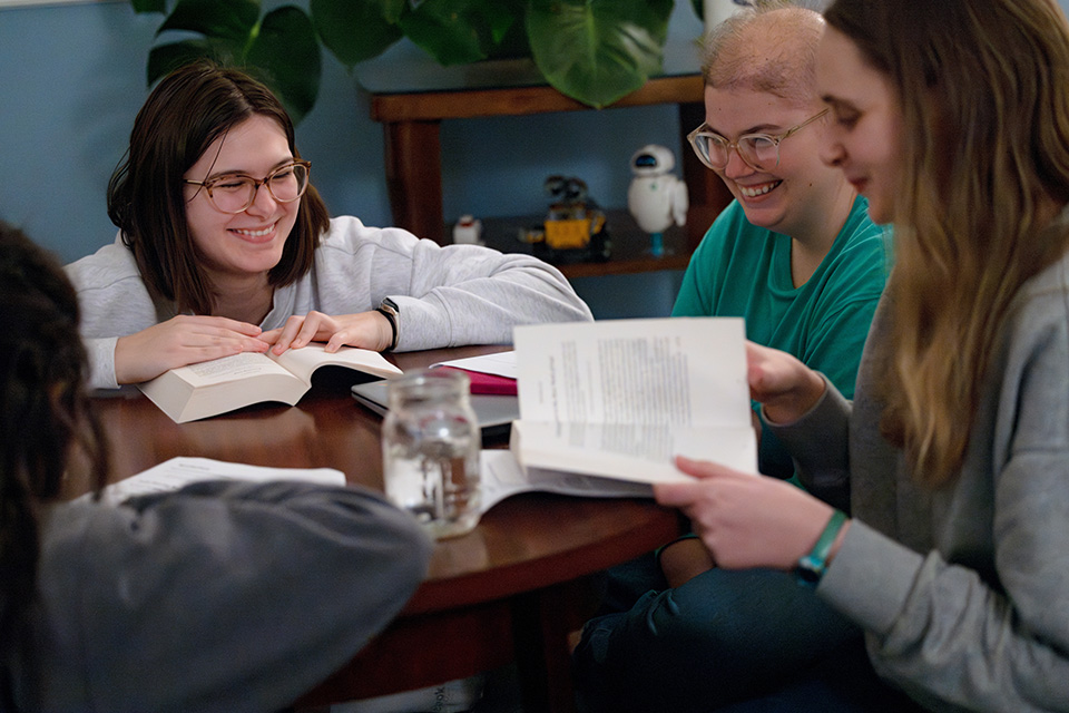 Three female Billiken Teachers talk around a round table.
