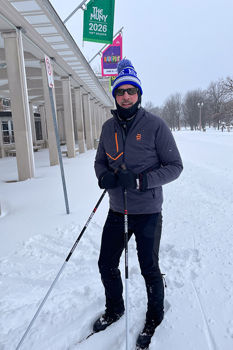 Feser cross-country skiing near the Muny A tall white man in winter gear on cross-country skis, in an urban park